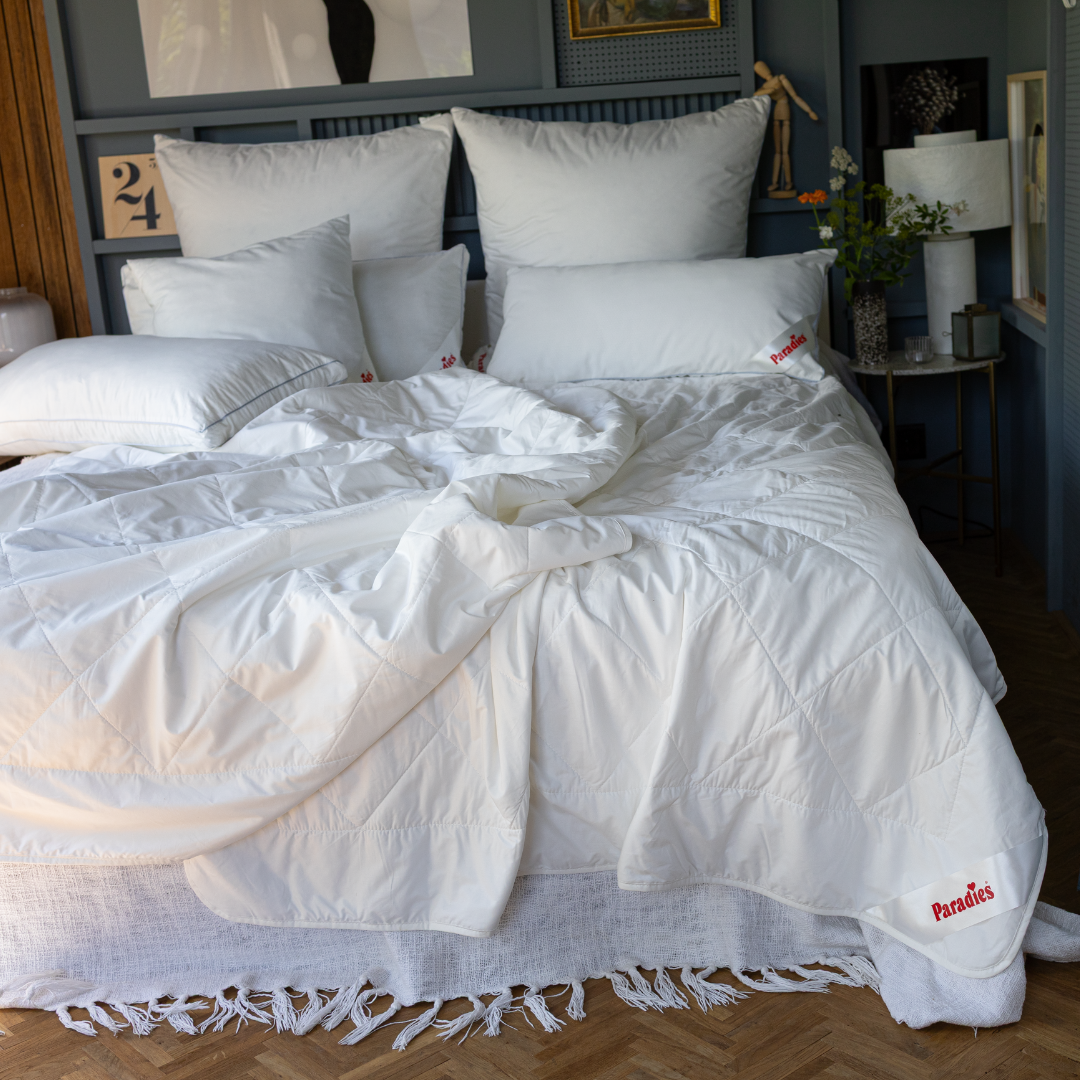 Weiße Paradies Cool Dream Bio Bettdecken auf einem Bett mit mehreren weißen Kissen in einem Schlafzimmer